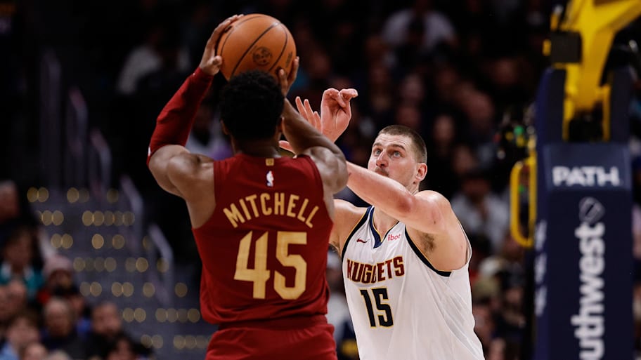 Cleveland Cavaliers guard Donovan Mitchell attempts a shot against Denver Nuggets center Nikola Jokic.