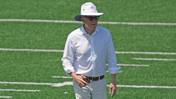 Woody Johnson walks on the field during organized team activities in May 2023.