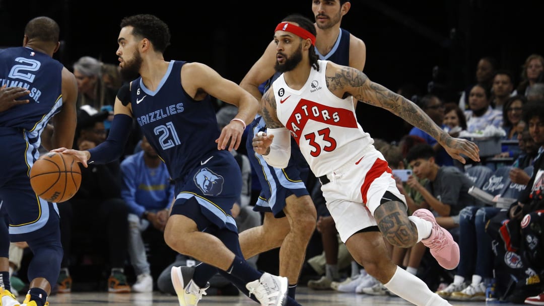 Feb 5, 2023; Memphis, Tennessee, USA; Memphis Grizzlies guard Tyus Jones (21) dribbles as Toronto Raptors guard Gary Trent Jr. (33) defends during the first half at FedExForum. Mandatory Credit: Petre Thomas-USA TODAY Sports