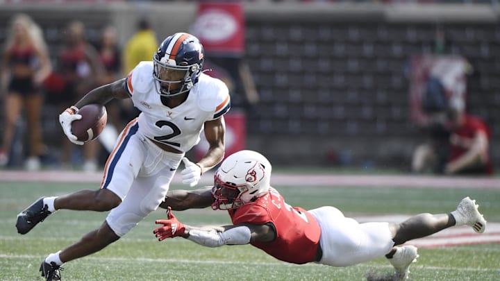 Oct 9, 2021; Louisville, Kentucky, USA;  Virginia Cavaliers wide receiver Ra'Shaun Henry (2) avoids the tackle of Louisville Cardinals defensive back Chandler Jones (2) during the second quarter at Cardinal Stadium. Mandatory Credit: Jamie Rhodes-Imagn Images