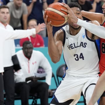 Jul 27, 2024; Villeneuve-d'Ascq, France; Greece small forward Giannis Antetokounmpo (34) controls the ball against Canada centre Trey Lyles (8) and point guard Andrew Nembhard (19) during the Paris 2024 Olympic Summer Games at Stade Pierre-Mauroy. Mandatory Credit: John David Mercer-USA TODAY Sports