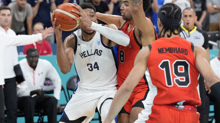 Jul 27, 2024; Villeneuve-d'Ascq, France; Greece small forward Giannis Antetokounmpo (34) controls the ball against Canada centre Trey Lyles (8) and point guard Andrew Nembhard (19) during the Paris 2024 Olympic Summer Games at Stade Pierre-Mauroy. Mandatory Credit: John David Mercer-USA TODAY Sports