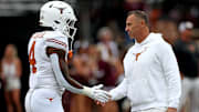 Starkville, Mississippi, USA; Texas Longhorns head coach Steve Sarkisian (right) talks with Texas Longhorns running back CJ Baxter Jr. (4) during warm ups prior to the game against the Mississippi State Bulldogs at Davis Wade Stadium at Scott Field.