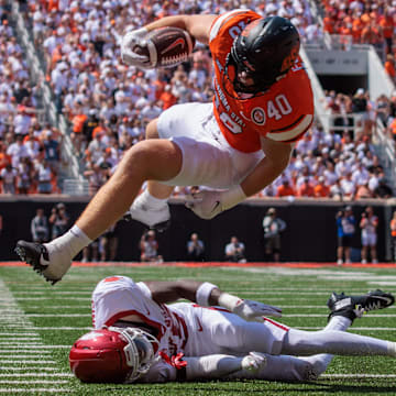 Oklahoma State Cowboys tight end Josh Ford (40) leaps over Arkansas Razorbacks defensive back Jaheim Singletary (15) during the fourth quarter at Boone Pickens Stadium.