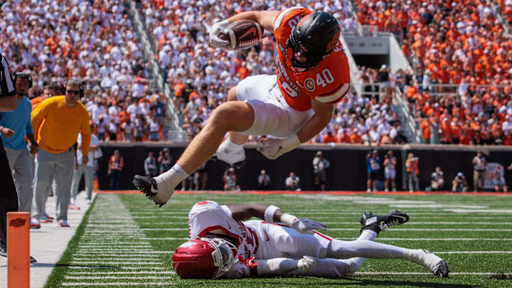 Oklahoma State Cowboys tight end Josh Ford (40) leaps over Arkansas Razorbacks defensive back Jaheim Singletary (15) during the fourth quarter at Boone Pickens Stadium.