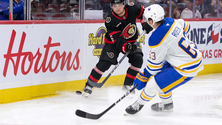 Sep 26, 2024; Ottawa, Ontario, CAN; Ottawa Senators defenseman Calen Addison (6) moves the puck past Buffalo Sabres right wing Isak Rosen (63) in the second period at the Canadian Tire Centre. Mandatory Credit: Marc DesRosiers-Imagn Images