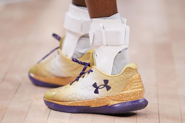 Sacramento Kings guard De'Aaron Fox's gold and purple Under Armour shoes.