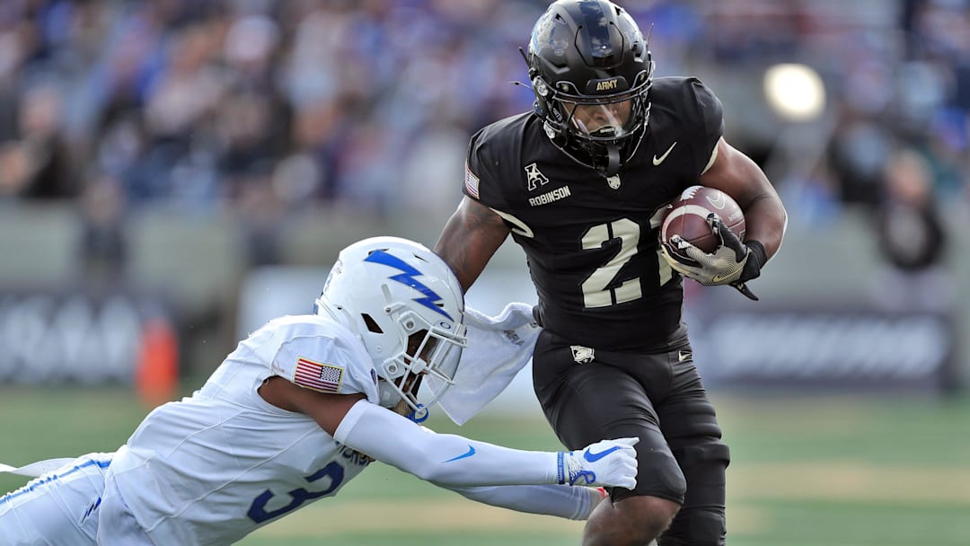 Nov 2, 2024; West Point, New York, USA; Army Black Knights running back Tyrell Robinson (21) tries to get by Air Force Falcons defensive back Jamari Bellamy (3) during the first half at Michie Stadium. 