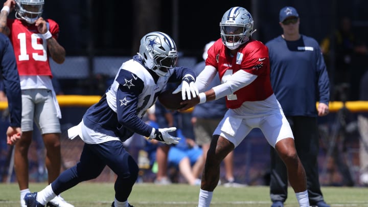 Jul 31, 2024; Oxnard, CA, USA; Dallas Cowboys quarterback Dak Prescott (4) hands off to running back Ezekiel Elliott (15) during training camp at the River Ridge Playing Fields in Oxnard, California. 