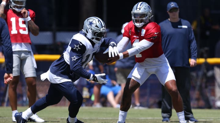 Jul 31, 2024; Oxnard, CA, USA; Dallas Cowboys quarterback Dak Prescott (4) hands off to running back Ezekiel Elliott (15) during training camp at the River Ridge Playing Fields in Oxnard, California.  Mandatory Credit: Jason Parkhurst-USA TODAY Sports