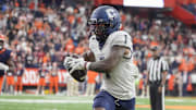 Sep 6, 2025; Syracuse, New York, USA; UConn Huskies wide receiver Skyler Bell (1) runs after making a catch against the Syracuse Orange during overtime at JMA Wireless Dome. Mandatory Credit: Gregory Fisher-Imagn Images