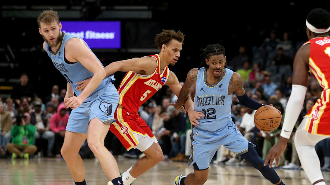 Jan 21, 2026; Memphis, Tennessee, USA; Memphis Grizzlies guard Ja Morant (12) dribbles around a screen set by center Jock Landale (31) on Atlanta Hawks guard Dyson Daniels (5) during the fourth quarter at FedExForum. Mandatory Credit: Petre Thomas-Imagn Images