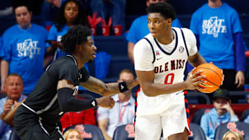 Feb 15, 2025; Oxford, Mississippi, USA; Mississippi Rebels forward Malik Dia (0) handles the ball as Mississippi State Bulldogs forward Cameron Matthews (4) defends during the first half at The Sandy and John Black Pavilion at Ole Miss. Mandatory Credit: Petre Thomas-Imagn Images