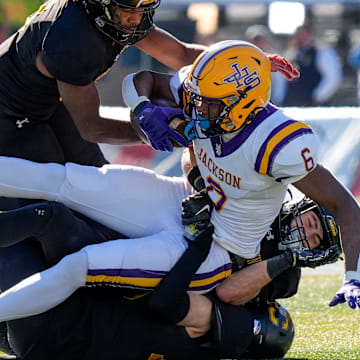 Dec 6, 2024; Birmingham, AL, USA; A trio of Cherokee County defenders bring down Jackson's Keeyun Chapman (6) at Protective Stadium in the AHSAA 4A State Championship game.