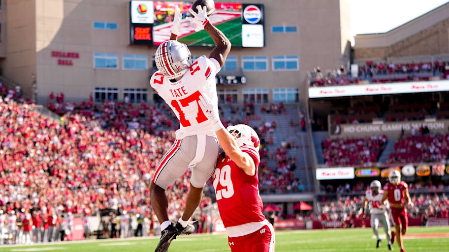 Carnell Tate leaps to make a catch over a defender.