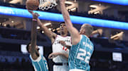 Nov 22, 2025; Charlotte, North Carolina, USA; Los Angeles Clippers guard Cam Christie (12) drives in past Charlotte Hornets guard Brandon Miller (24) and center Mason Plumlee (22) during the second half at the Spectrum Center. Mandatory Credit: Sam Sharpe-Imagn Images