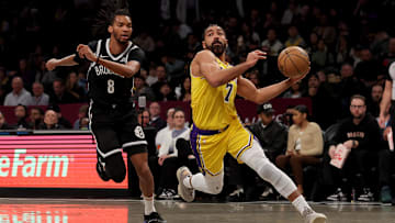Mar 10, 2025; Brooklyn, New York, USA; Los Angeles Lakers guard Gabe Vincent (7) drives to the basket against Brooklyn Nets forward Ziaire Williams (8) during the first quarter at Barclays Center. Mandatory Credit: Brad Penner-Imagn Images