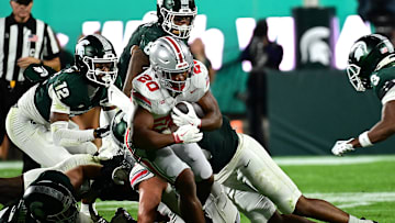 Sep 28, 2024; East Lansing, Michigan, USA;  Ohio State Buckeyes running back James Peoples (20) struggles for a first down against the Michigan State Spartans in the fourth quarter at Spartan Stadium. Mandatory Credit: Dale Young-Imagn Images