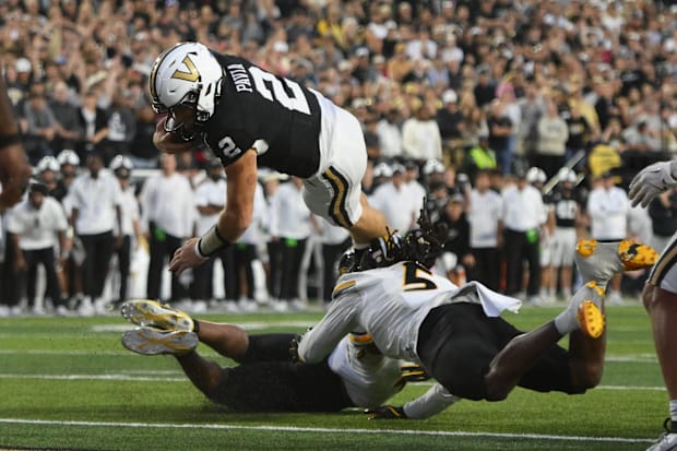 Vanderbilt quarterback Diego Pavia dives over Missouri defenders for a one-yard touchdown.