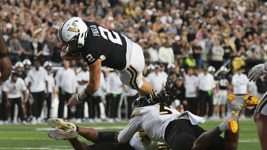 Vanderbilt quarterback Diego Pavia dives over Missouri defenders for a one-yard touchdown.