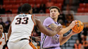 Jan 7, 2025; Stillwater, Oklahoma, USA; Kansas State Wildcats guard Coleman Hawkins (33) looks to pass around Oklahoma State Cowboys forward Abou Ousmane (33) during the second half at Gallagher-Iba Arena. Mandatory Credit: William Purnell-Imagn Images