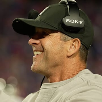 Baltimore Ravens head coach John Harbaugh smiles after his team scores a touchdown.