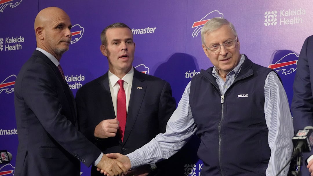 Pete Guelli, president of business operations, Brandon Beane, president of football operations and general manager, shake hands with owner and president Terry Pegula after a group photo with new Bills head coach Joe Brady on Jan. 29, 2026 at the Bills field house.