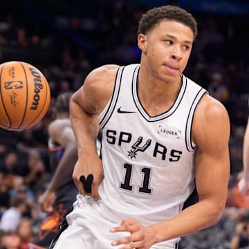 Nov 2, 2025; Phoenix, Arizona, USA; San Antonio Spurs forward Carter Bryant (11) reacts after scores during the second half against the Phoenix Suns at Mortgage Matchup Center.