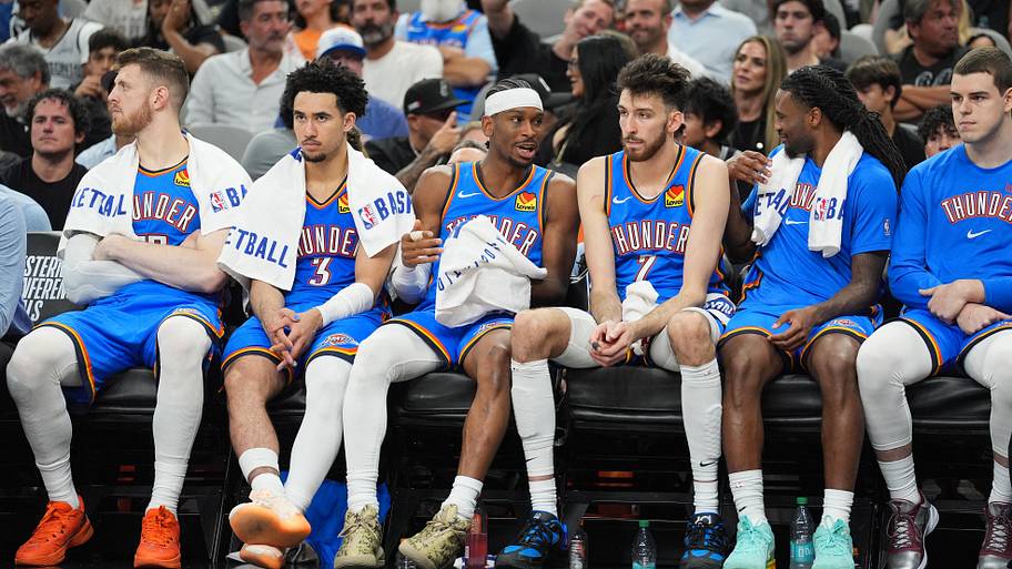 Oklahoma City Thunder guard Shai Gilgeous-Alexander exchanges words with center Chet Holmgren on the bench.