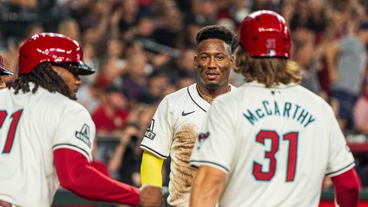 Sep 15, 2024; Phoenix, Arizona, USA; Arizona Diamondbacks infielder Geraldo Perdomo (2) reacts with outfielder Jake McCarthy (31) and infielder Josh Bell (21) after scoring in the third inning during a game against the Milwaukee Brewers at Chase Field. Mandatory Credit: Allan Henry-USA TODAY Sports