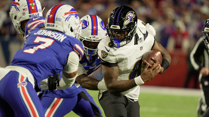 Baltimore Ravens quarterback Lamar Jackson tries to avoid Buffalo Bills cornerback Dorian Strong and cornerback Taron Johnson Baltimore Ravens quarterback Lamar Jackson tries to avoid Buffalo Bills cornerback Dorian Strong and cornerback Taron Johnson