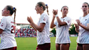 Arkansas soccer players cheer on teammates before a match.