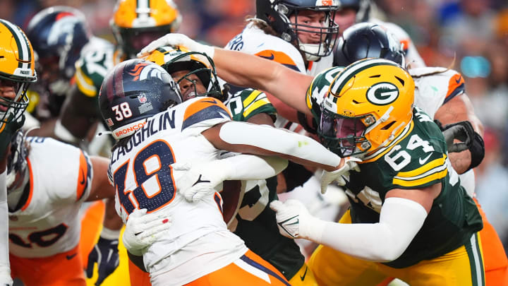 Green Bay Packers defensive end Kingsley Enagbare (55) and defensive end Spencer Waege (64) tackle Denver Broncos running back Jaleel McLaughlin.