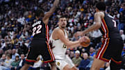 Nov 5, 2025; Denver, Colorado, USA; Miami Heat forward Andrew Wiggins (22) and center Kel'el Ware (7) defend on Denver Nuggets center Nikola Jokic (15) in the second quarter at Ball Arena. Mandatory Credit: Ron Chenoy-Imagn Images