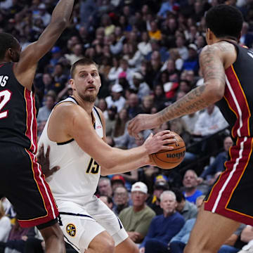 Nov 5, 2025; Denver, Colorado, USA; Miami Heat forward Andrew Wiggins (22) and center Kel'el Ware (7) defend on Denver Nuggets center Nikola Jokic (15) in the second quarter at Ball Arena. Mandatory Credit: Ron Chenoy-Imagn Images