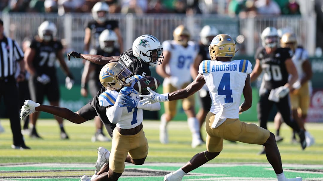 Aug 31, 2024; Honolulu, Hawaii, USA; UCLA Bruins defensive back K.J. Wallace (7) can’t pull in an interception over Hawaii Rainbow Warriors wide receiver Pofele Ashlock (5) during the fourth quarter of an NCAA college football game at the Clarence T.C. Ching Athletics Complex. Mandatory Credit: Marco Garcia-Imagn Images