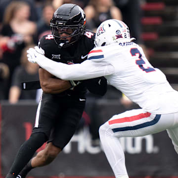 Arizona Wildcats defensive back Treydan Stukes (2) tackles Cincinnati Bearcats wide receiver Cyrus Allen (4) in the second quarter of the NCAA football at Nippert Stadium in Cincinnati on Nov. 15, 2025.