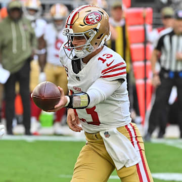Nov 16, 2025; Glendale, Arizona, USA; San Francisco 49ers quarterback Brock Purdy (13) hands off the ball in the first half against the Arizona Cardinals at State Farm Stadium. Mandatory Credit: Matt Kartozian-Imagn Images
