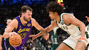 Mar 13, 2025; Milwaukee, Wisconsin, USA;  Los Angeles Lakers guard Luka Doncic (77) drives to the basket against Milwaukee Bucks center Jericho Sims (00) in the fourth quarter at Fiserv Forum. Mandatory Credit: Benny Sieu-Imagn Images