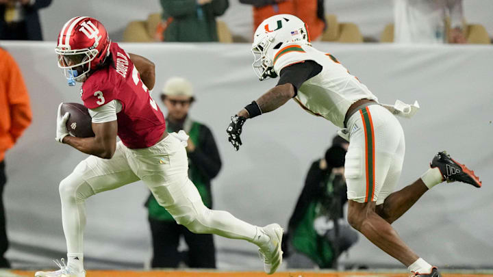 Miami (FL) Hurricanes safety Zechariah Poyser (7) chases after Indiana Hoosiers wide receiver Omar Cooper Jr. (3) as he rushes the ball Monday, Jan. 19, 2026, during the College Football Playoff National Championship college football game at Hard Rock Stadium in Miami Gardens.