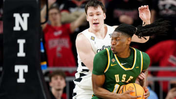 San Francisco Dons forward Jonathan Mogbo (10) spins toward the basket as Cincinnati Bearcats guard Simas Lukosius (41) defends in the second half of a college basketball game in the National Invitation Tournament, Wednesday, March 20, 2024, at Fifth Third Arena in Cincinnati.