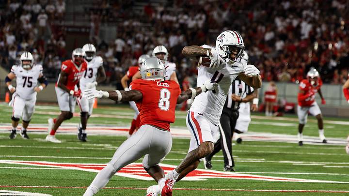 Aug 31, 2024; Tucson, Arizona, USA; Arizona Wildcats wide receiver Tetairoa McMillan (4) dodges tackle by New Mexico Lobos safety Christian Ellis (8) during third quarter at Arizona Stadium. Mandatory Credit: Aryanna Frank-USA TODAY Sports