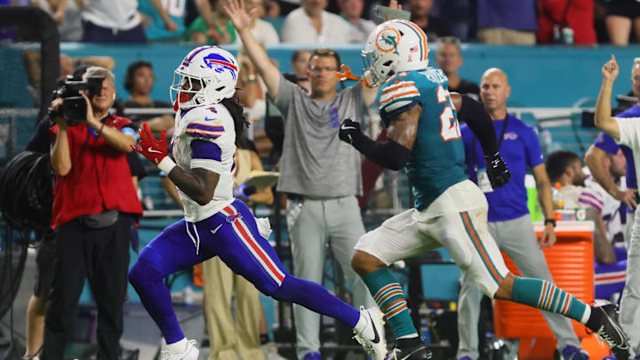 Buffalo Bills running back James Cook (4) runs with the football for a touchdown ahead of Miami Dolphins safety Jordan Poyer (21) during the second quarter at Hard Rock Stadium.