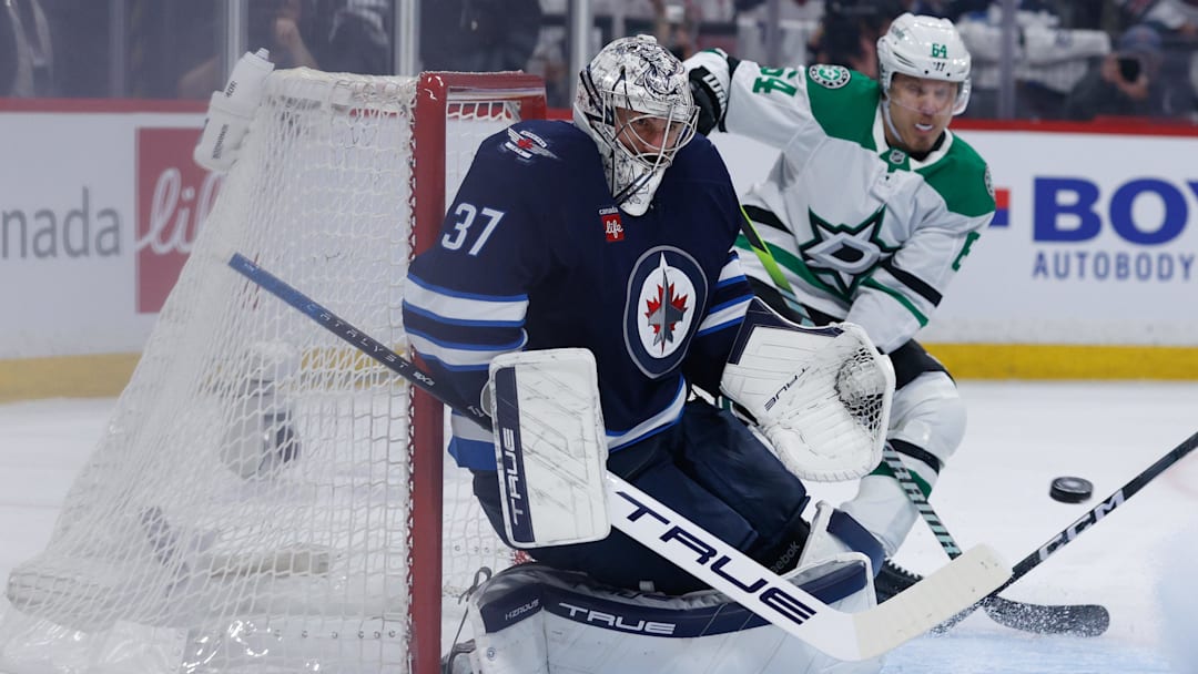 May 15, 2025; Winnipeg, Manitoba, CAN; Winnipeg Jets goalie Connor Hellebuyck (37) watches a Dallas Stars shot during the first period in game five of the second round of the 2025 Stanley Cup Playoffs at Canada Life Centre. Mandatory Credit: Terrence Lee-Imagn Images