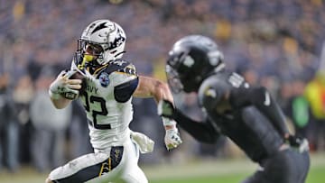 Dec 14, 2024; Landover, Maryland, USA; Navy Midshipmen running back Eli Heidenreich (22) runs with the ball against the Army Black Knights during the second half of the the 125th Army-Navy game at Northwest Stadium.