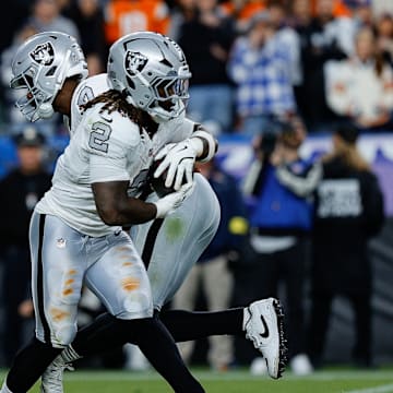 Nov 6, 2025; Denver, Colorado, USA; Las Vegas Raiders quarterback Geno Smith (7) hands the ball off to running back Ashton Jeanty (2) in the fourth quarter against the Denver Broncos at Empower Field at Mile High. Mandatory Credit: Isaiah J. Downing-Imagn Images