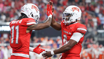 Ricky White III #11and Hajj-Malik Williams #6 of the UNLV Rebels celebrate after a touchdown during the fourth quarter of a game against the Syracuse Orange at Allegiant Stadium on October 04, 2024 in Las Vegas, Nevada.
