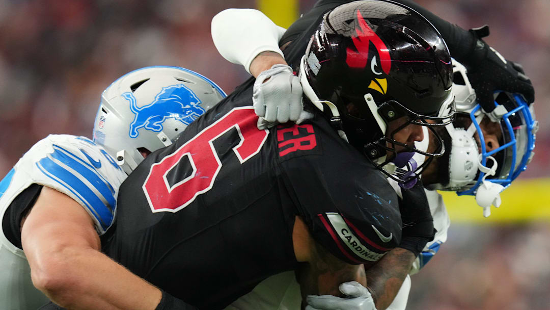 Arizona Cardinals running back James Conner (6) is tackled by Detroit Lions defenders Carlton Davis (23) and Jack Campbell (46) at State Farm Stadium in Glendale, Ariz., on Sep 22, 2024.