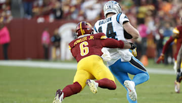 Oct 20, 2024; Landover, Maryland, USA; Carolina Panthers quarterback Andy Dalton (14). Is tackled by Washington Commanders linebacker Dante Fowler Jr. (6) during the fourth quarter at Northwest Stadium. Mandatory Credit: Geoff Burke-Imagn Images
