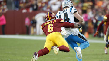 Oct 20, 2024; Landover, Maryland, USA; Carolina Panthers quarterback Andy Dalton (14). Is tackled by Washington Commanders linebacker Dante Fowler Jr. (6) during the fourth quarter at Northwest Stadium. Mandatory Credit: Geoff Burke-Imagn Images